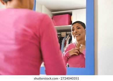 close up shot of Non-binary person getting ready, adjusting clothing and smiling in apartment