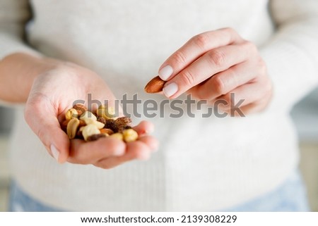 Close up shot of nuts in woman hands. Female holding healthy snacks