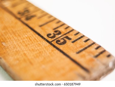 Close shot of an old yardstick showing the number 35.  Low angle with shallow depth of field.