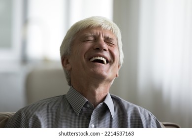 Close Up Shot, Older Man Laughing At Witty Joke, Happy Senior Giggling With Eyes Closed Seated On Sofa At Home, Spend Weekend Leisure Watching Amusing TV Show, Entertainment And Fun, Positive Emotions