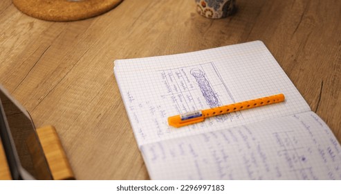 Close up shot of open copybook with squared sheets near mobile phone. High school or college student prepares for certification examination using smartphone. High quality photo