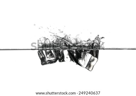 A close up shot of a pair of ice cubes falling into a water basin