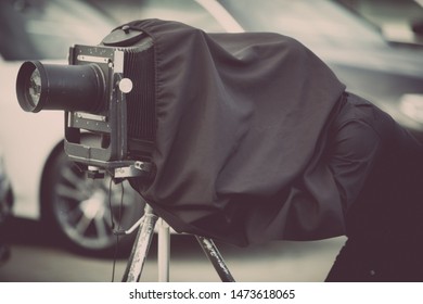 Close up shot of a photographer using a vintage camera on a tripod.