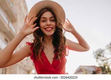 Close Shot Photography Of Cheerful Girl Touching Her Hat And Beautiful Long Hair. Woman Happy To Be Outside After The Lockdown And Enjoy The Summer And Warm Weather In Her Favourite Dress 