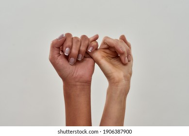Close up shot of pinky swear. Promise hand gesture isolated over light background. Horizontal shot