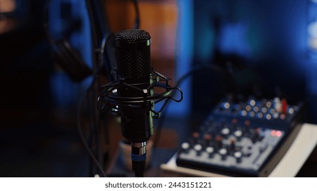 Close up shot of professional microphone used to record podcast conversations for online livestreaming channel. High quality sound capturing and recording gear in apartment studio