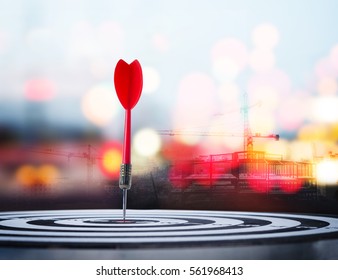 Close up shot red dart arrow on center of dartboard with construction and bokeh blur background , metaphor to target success, winner concept,  - Shutterstock ID 561968413