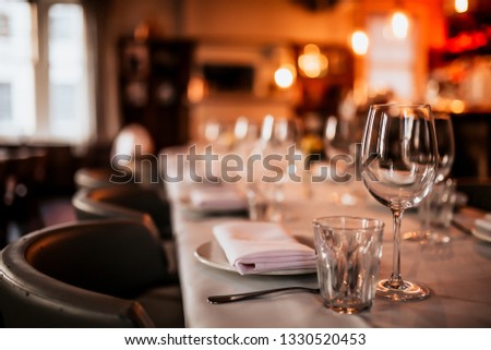 A close up shot of a restaurant table set up with tableware and wine glass. Concept of dining, hospitality and catering. Horizontal image with free space for text. 