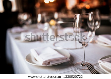 A close up shot of a restaurant table set up with tableware and wine glass. Concept of dining, hospitality and catering. Horizontal image with free space for text. 
