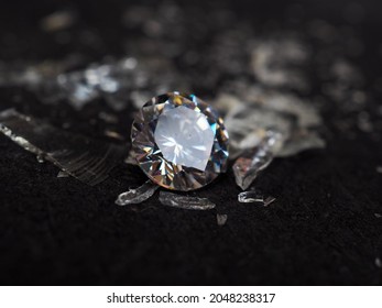 Close up shot of roud cut zircon zirconia gems with broken glass surrounded. Shoot on a black background.