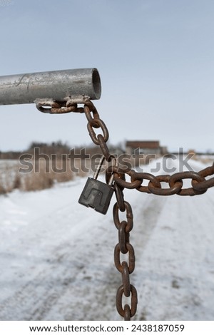 Close up shot of a rusted chain locked up to prevent entry to a farm building structure.  