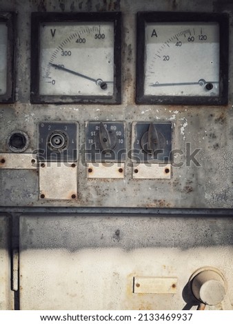 Close up shot of a rusty old large voltmeter and amperemeter.