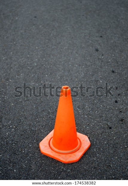 A close up shot\
of a safety cone on a road