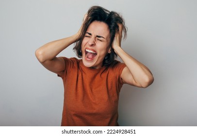 Close up shot of screaming crazy frustrated woman with anxiety, anger and depression. Very upset and emotional woman crying. Young girl with angry and furious face. Human expressions and emotions - Shutterstock ID 2224928451