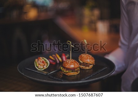 A close up shot of a selection of canape dishes. Concept of catering, hospitality and lifestyle. Small snacks and nibbles served on black slates for a private reception. 