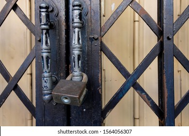 Close up shot selective focus rusty aged Metal folding sliding door with lock. Vintage unique architecture outdoor design style that see only in Old town. 