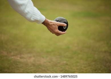 A Close Up Shot Of A Senior Adult Holding A Bocce Ball, Ready To Take Their Shot In A Lawn Bowl Game.