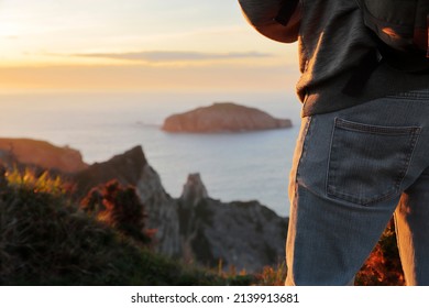 Close Up Shot Of The Side And Thigh Of An Unrecognizable Man Enjoying The Sunset Over The Sea, Making Use Of Selective Focus. Concept Of Travel And Wellness. Horizontal.