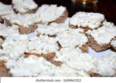 Close up shot of Soft cheese paste based cream spread on whole wheat brown bread, cut into slices and served as finger food 