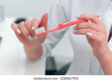 Captura de pantalla de algunas manos hembras mostrando un cepillo dental y sus piquetes suaves.