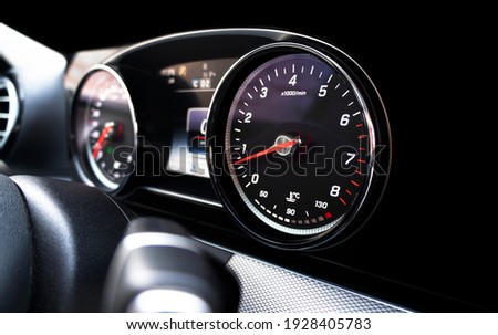 Close up shot of a speedometer in a car. Car dashboard. Dashboard details with indication lamps. Car instrument panel. Dashboard with speedometer, tachometer, odometer. Car detailing.