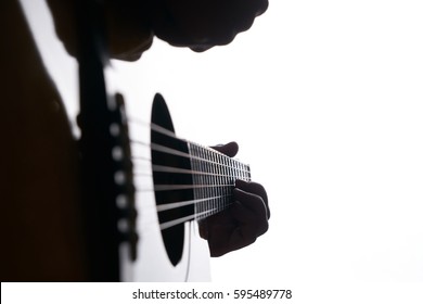 Close Up Shot Of Strings And Guitarist Hands Playing Acoustic Guitar Over White