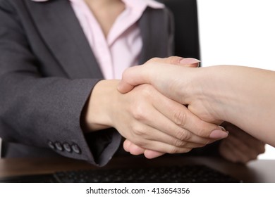 close up shot of two business women shaking hands. 