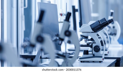 Close Up Shot Of Two Eyes Viewfinder Scientific Microscope In Row Of One Eye Microscopes Line In Blurred Foreground On Laboratory Working Table Using For Monitoring Coronavirus Covid 19 Virus Samples.