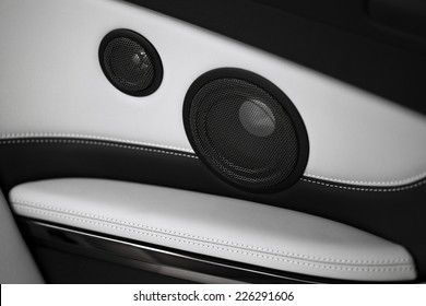 Close up shot of two round speakers in a car.