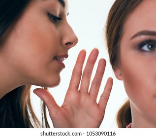 Close up shot of two young women sharing their secrets, studio shot. - Powered by Shutterstock