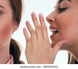 Close up shot of two young women sharing their secrets, studio shot. - Powered by Shutterstock