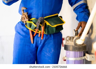 Close Up Shot Of Unrecongnizable Plumber Or Repairman Inspecting By Checking Water Filter Machine At Under Construction Site - Concept Of Blue Collar Worker Or Plumber Home Service.