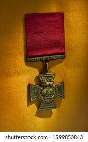 Close Up Shot Of Victoria Cross Medal On Golden Background