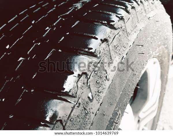 Close up shot of Wet Tire or Water drops on\
the tire background.