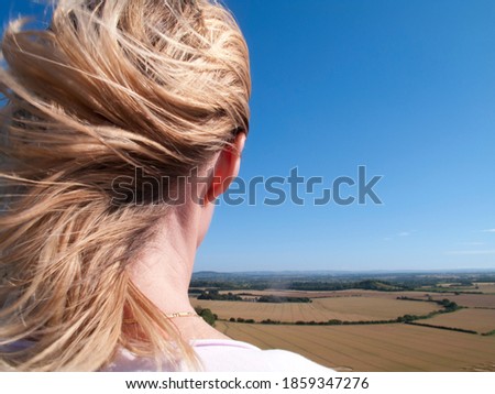 Similar – Landscape shot with wind turbines between fields and four flying cranes in front of a blue sky