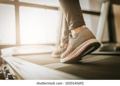 Close up shot of woman leg running in a gym on a treadmill for exercise. fitness and healthy lifestyle concept - Powered by Shutterstock