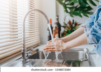 Close up shot of woman washing hands in sink before cooking at home kitchen.  - Powered by Shutterstock