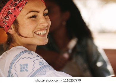 Close Up Shot Of Woman Wearing Bandana Driving A Car While On Road Trip With Friends. Smiling Woman On Road Trip With Friends.