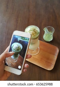 Close Up Shot Of A Women Hand Take A Snap Shot Of Green Tea Affogato For Post In Social Media Before Drink. Camera Eat First Concept, Mobile Photography.