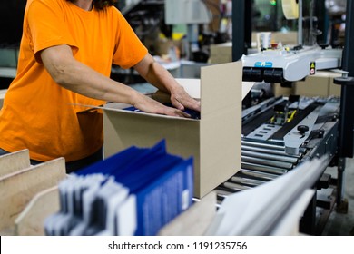 Close up shot of worker's hand preparing carton for printing in a modern printing house.