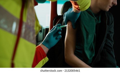 Close Up Shot Of A Young Male Getting A Vaccine Shot In His Arm By A Medical Worker In The Ambulance Car.