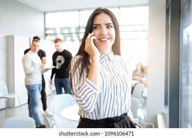 Close up shot of a young woman talking over phone. Happy businesswoman talking on mobile phone. Portrait of smiling businesswoman talking on cellphone at the office.