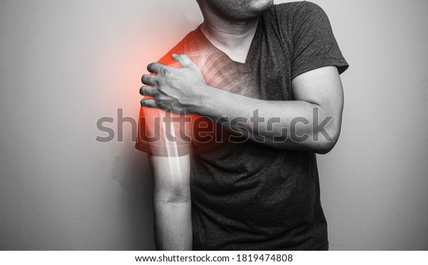 Close up Shoulder and clavicle\
fracture pain in a man, Young man holding his shoulder in pain \
Shoulder  inflammation symptoms medical healthcare\
concept.\
