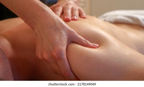 Close up shoulder massage. Man in a spa or salon getting a relaxing body massage by a professional masseuse. 