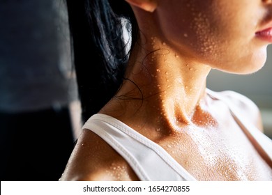 Close up shoulders and neck of a beautiful sporty girl in drop of sweat on skin after workout                     