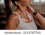 Close up of shoulders and neck fit female with sweat on skin after training, massaging neck muscles