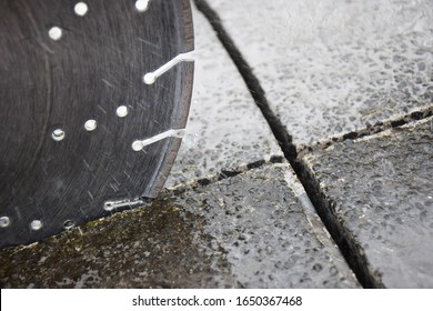 Close up showing a concrete cutter blade cutting into a concrete driveway
