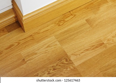 Close Up Showing Some Laminate Flooring And Mdf Imitation Wood Skirting Boards In Newly Constructed House