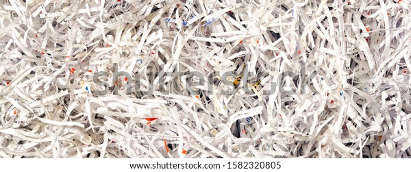 Close Up of Shredded Paper from a paper\
shredder. Paper Trimmings Waste. Cut Paper\
strips.