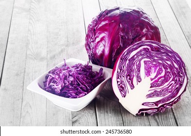 Close up Shredded, Sliced and a Whole of Purple Cabbage Vegetable on Top of Wooden Table